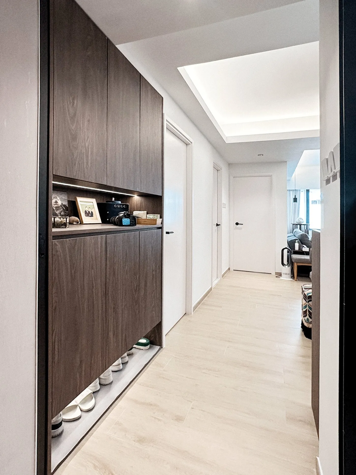 Entrance corridor with dark timber storage, a shoe bench and white doors