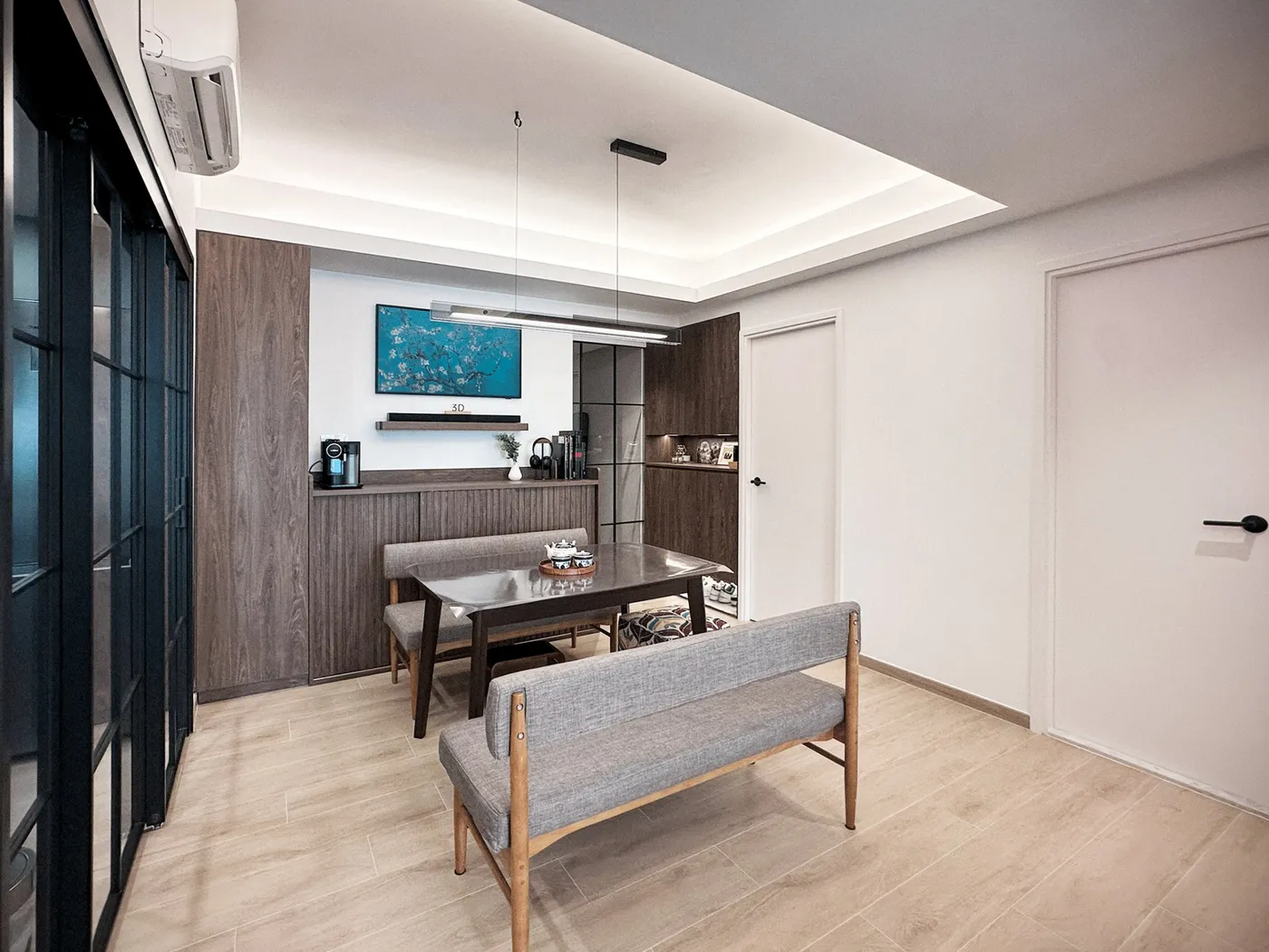 Dining area looking to the corridor, with a grey fabric bench, a dark timber sideboard and white walls