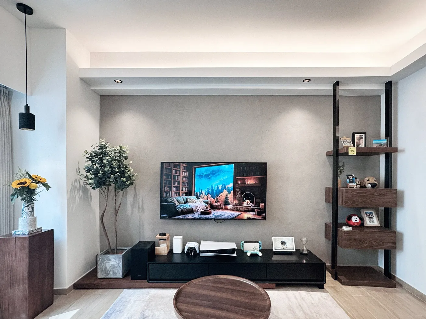 TV wall in a grey finish with a black low cabinet and timber shelving