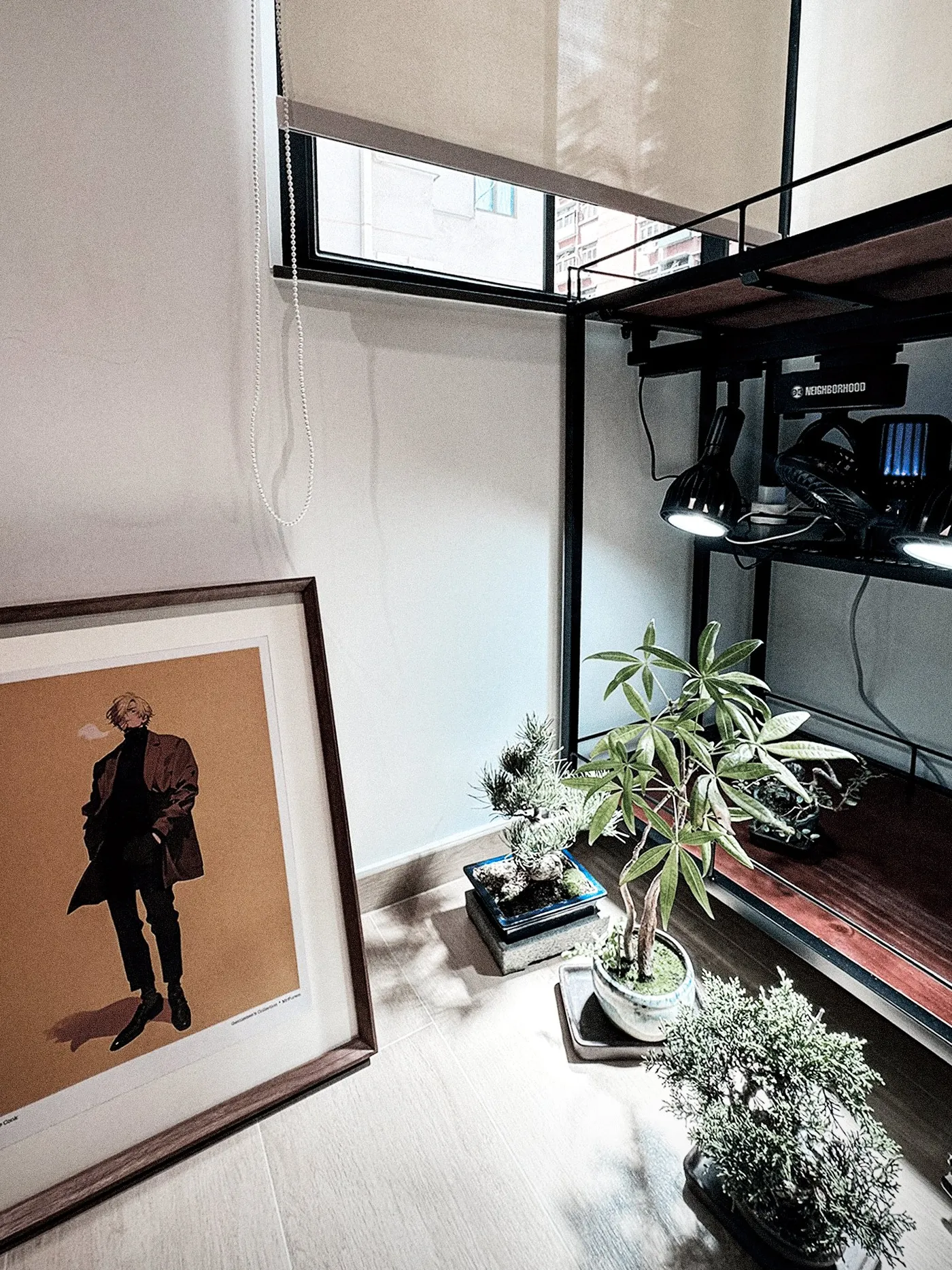 Study window corner with a large framed portrait, plants and a black shelf