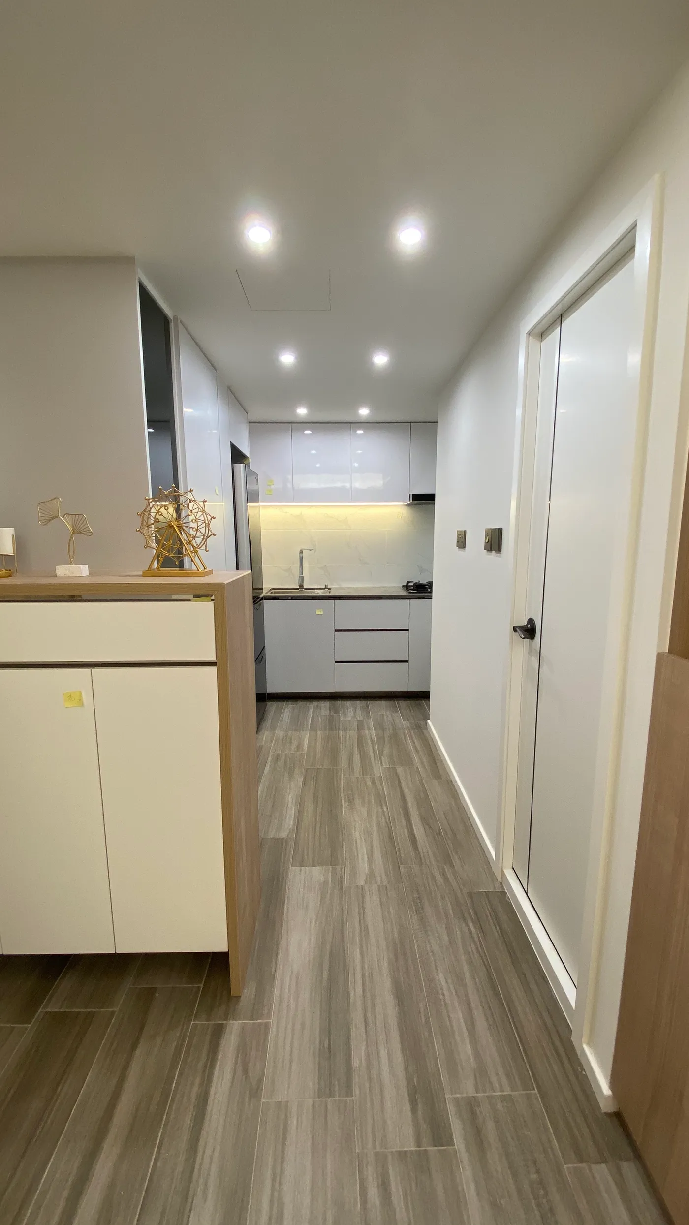Kitchen and utility corridor with glossy white kitchen cabinetry