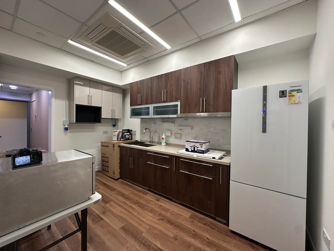 Pantry design with walnut-grain cabinetry and a marble-effect wall finish