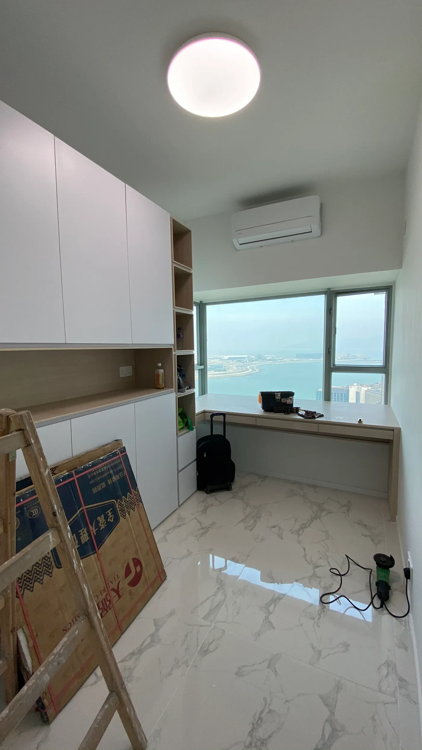 Bedroom bay-window desk and custom storage cabinetry, with sea views