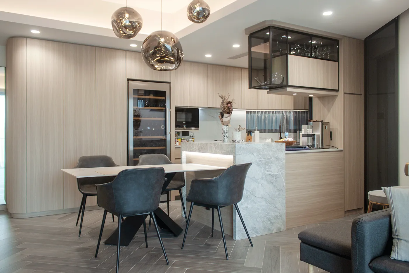 Stone-textured marble kitchen island paired with black glass overhead cabinets and a pendant light fixture
