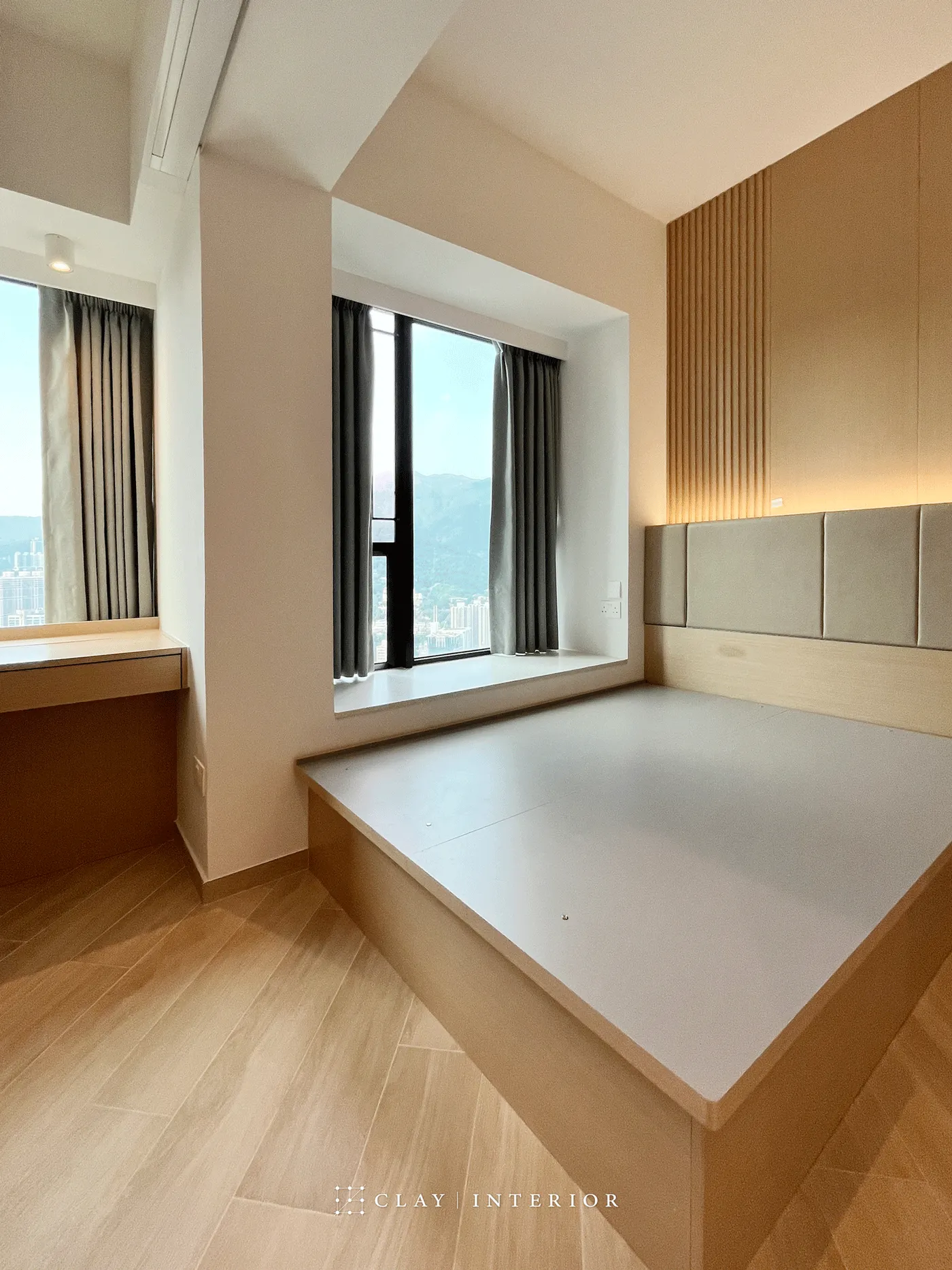 Bedroom platform bed and floor-to-ceiling windows overlooking the city