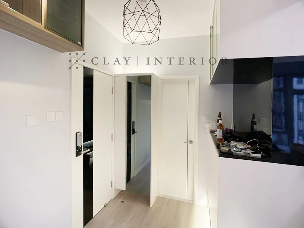 Corridor sliding door opening onto the open-plan kitchen, with a black countertop and glass-faced storage
