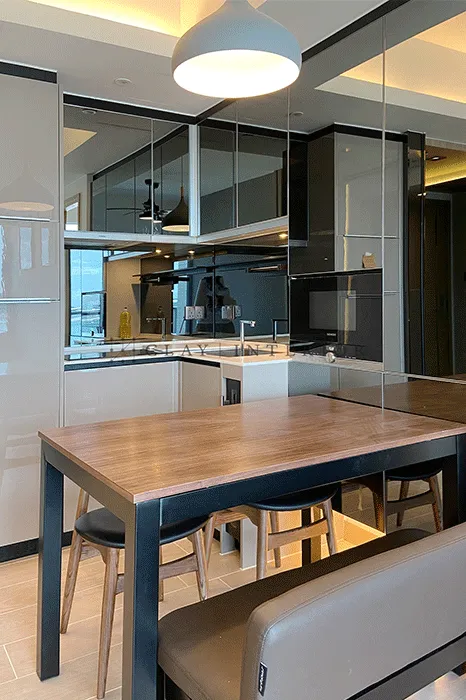 Kitchen and dining area with mirrored overhead cabinets, black countertop, and pendant lighting