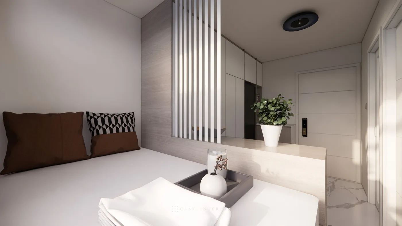 Bedroom corner by the bed, with vertical slat partition leading to the entrance