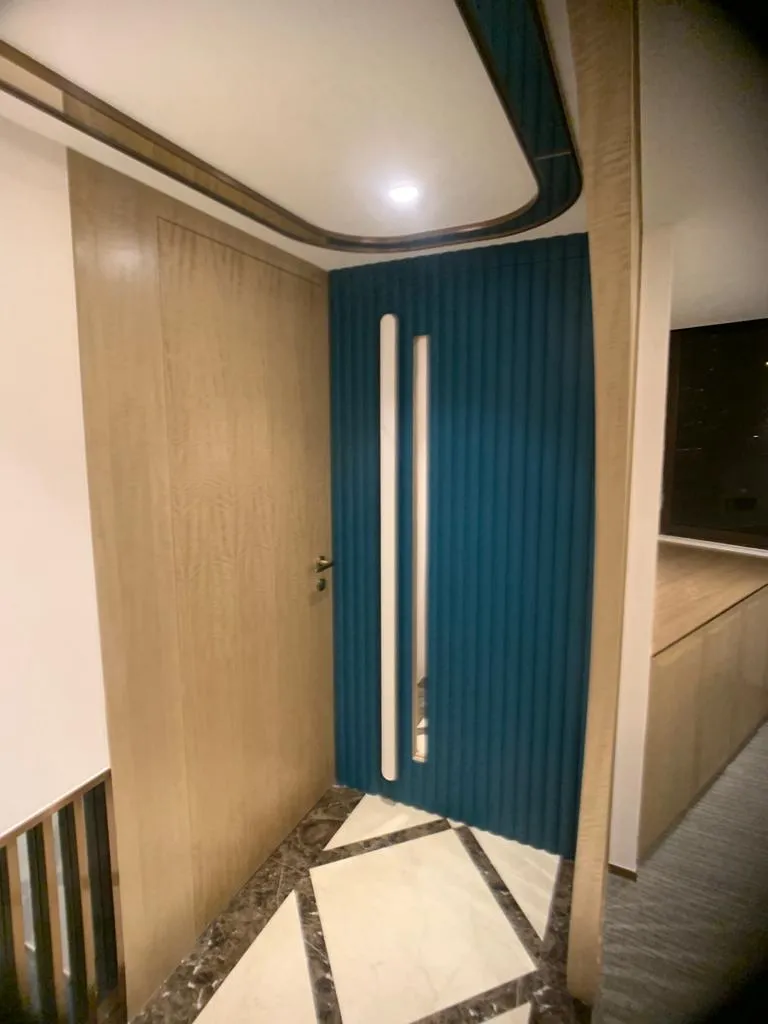 Entrance with a wood-grain door and a teal wave-patterned feature wall